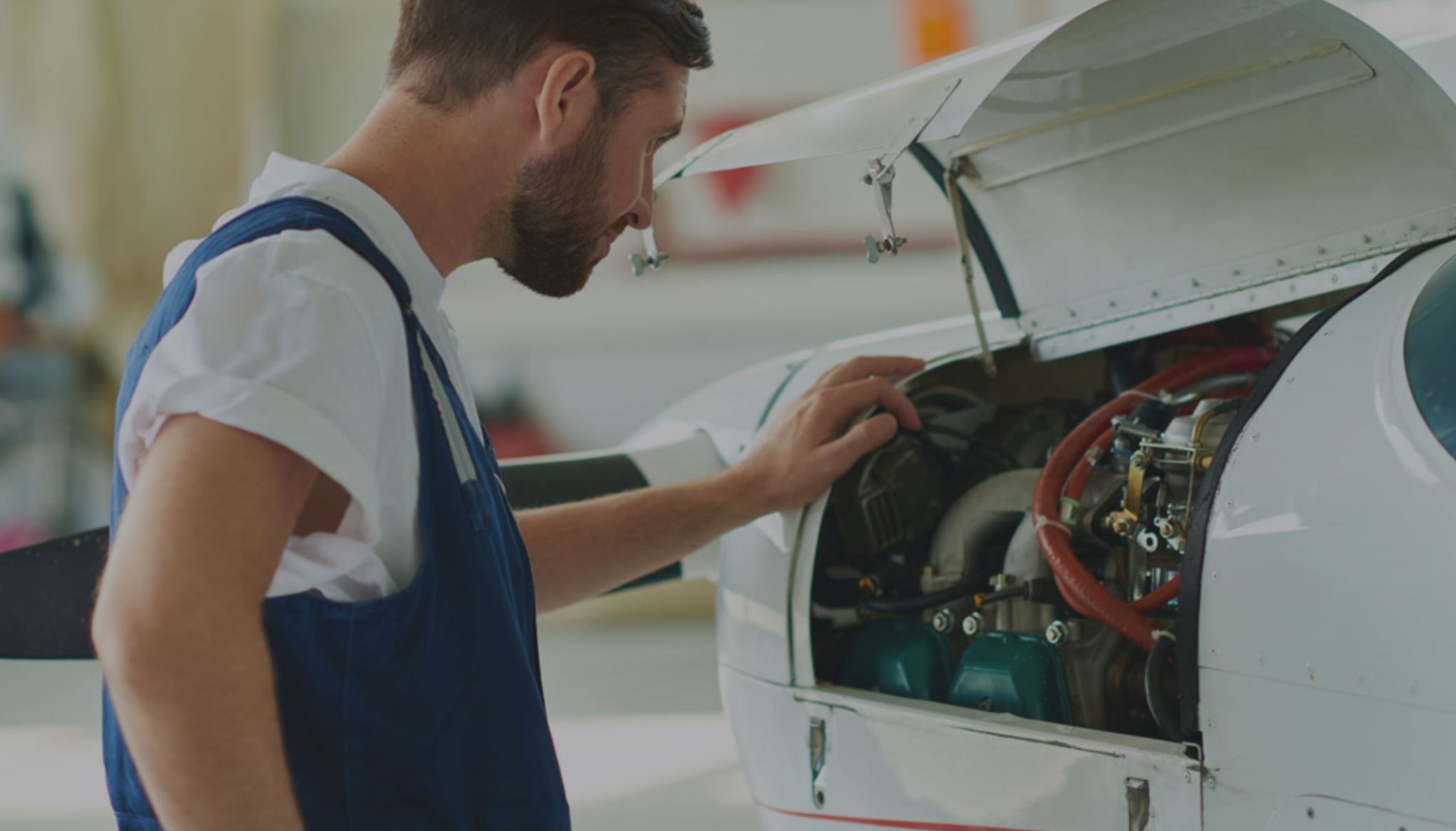 man looking at wires in engine