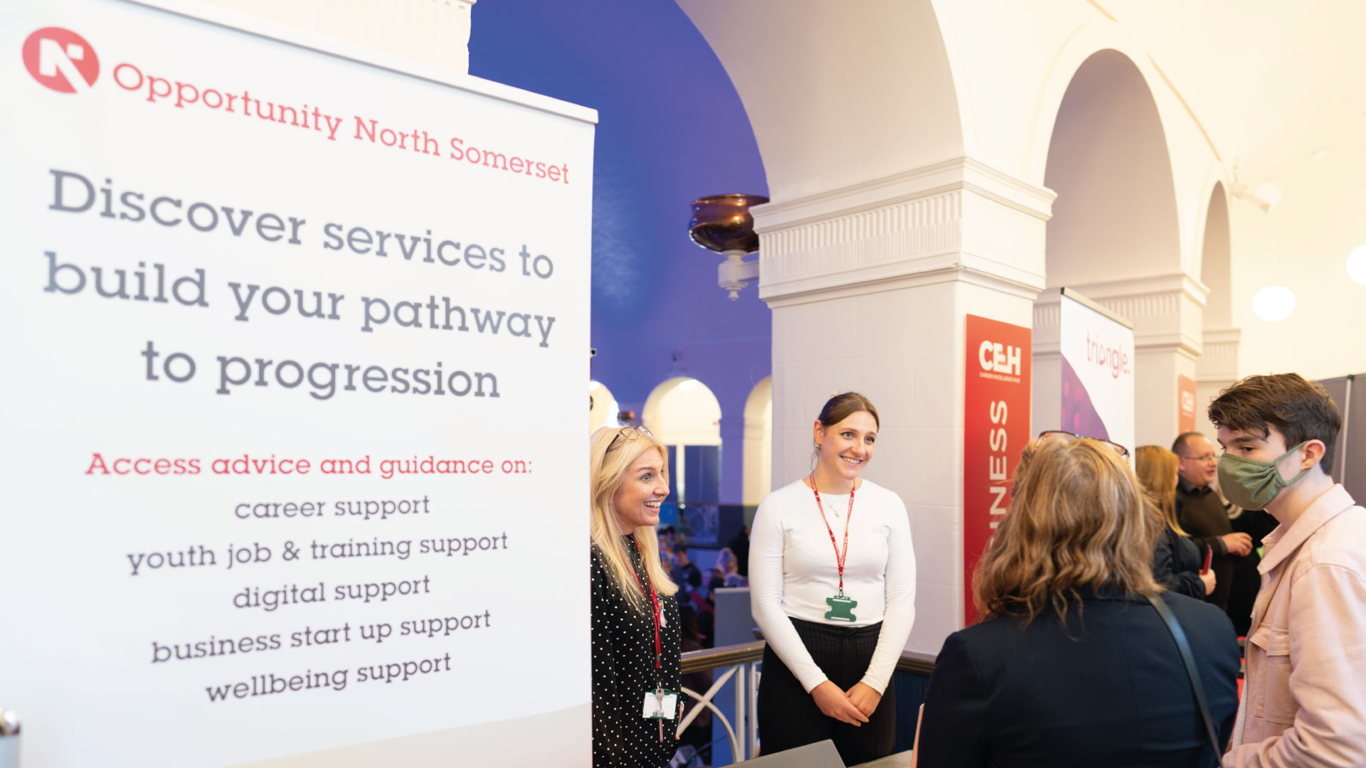Student and parent talk to business stand