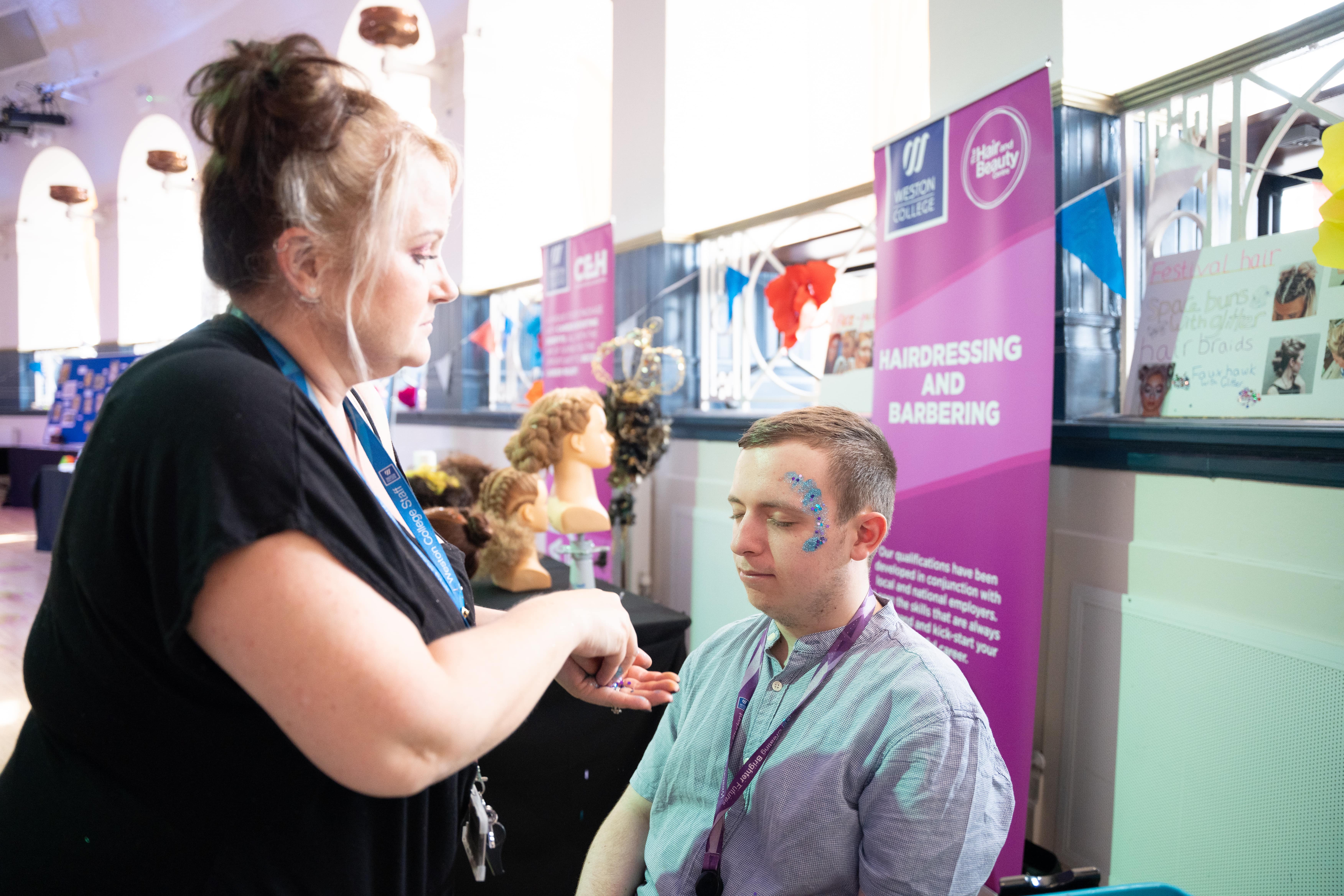 Women putting face glitter on a man