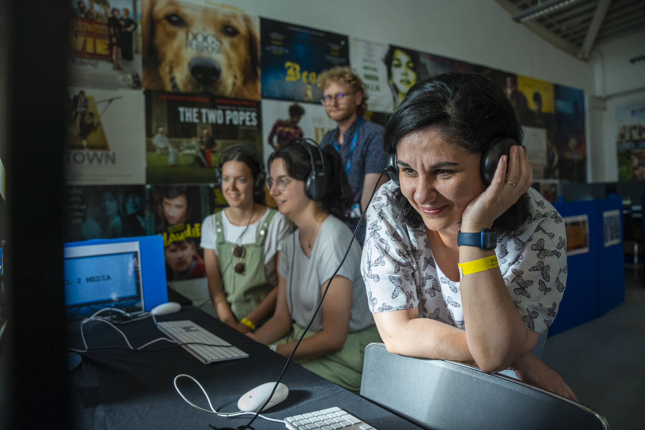 a woman sitting in front of a computer with headphones on
