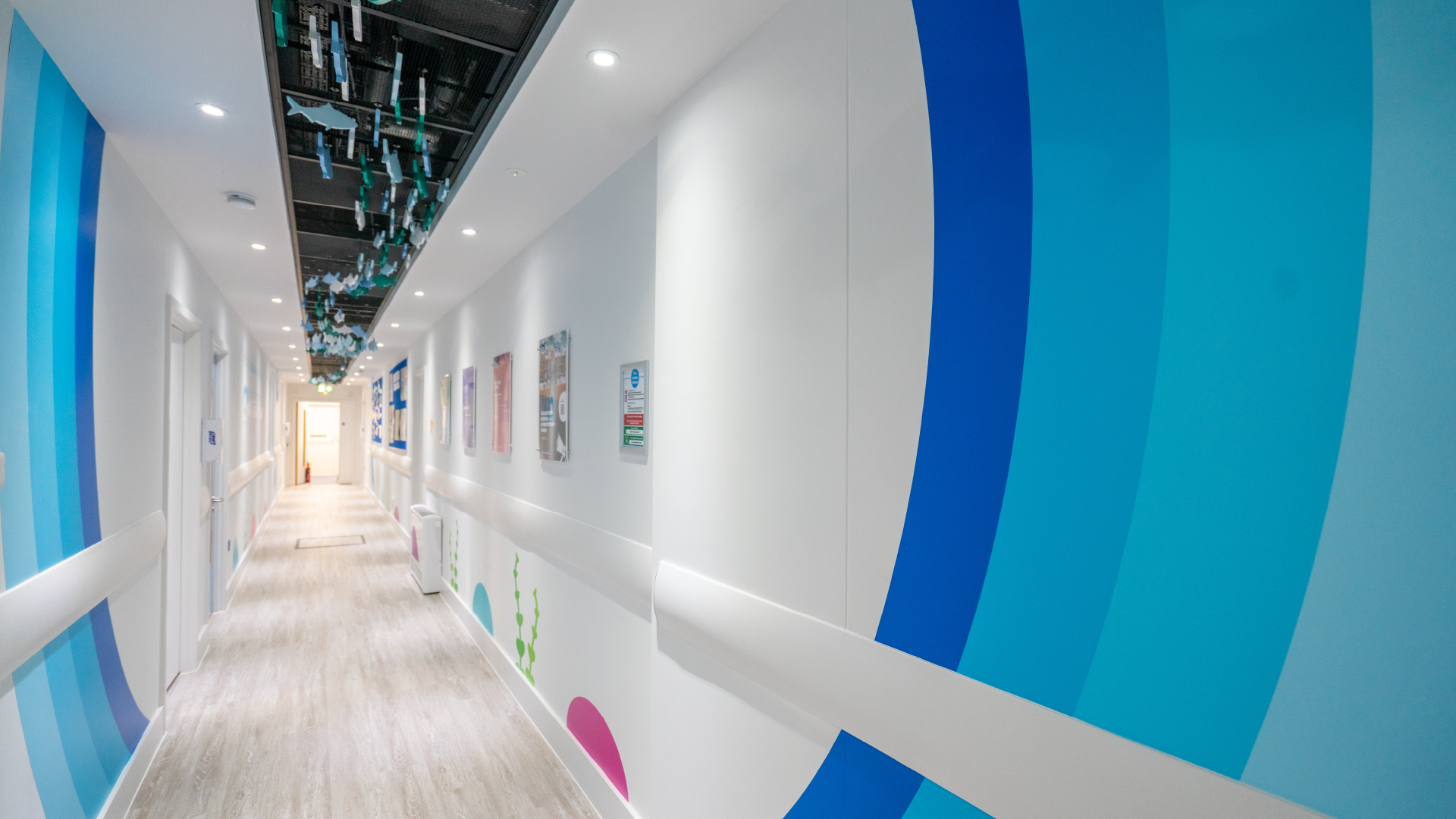 a hallway with a white wall with blue and white circles and signs