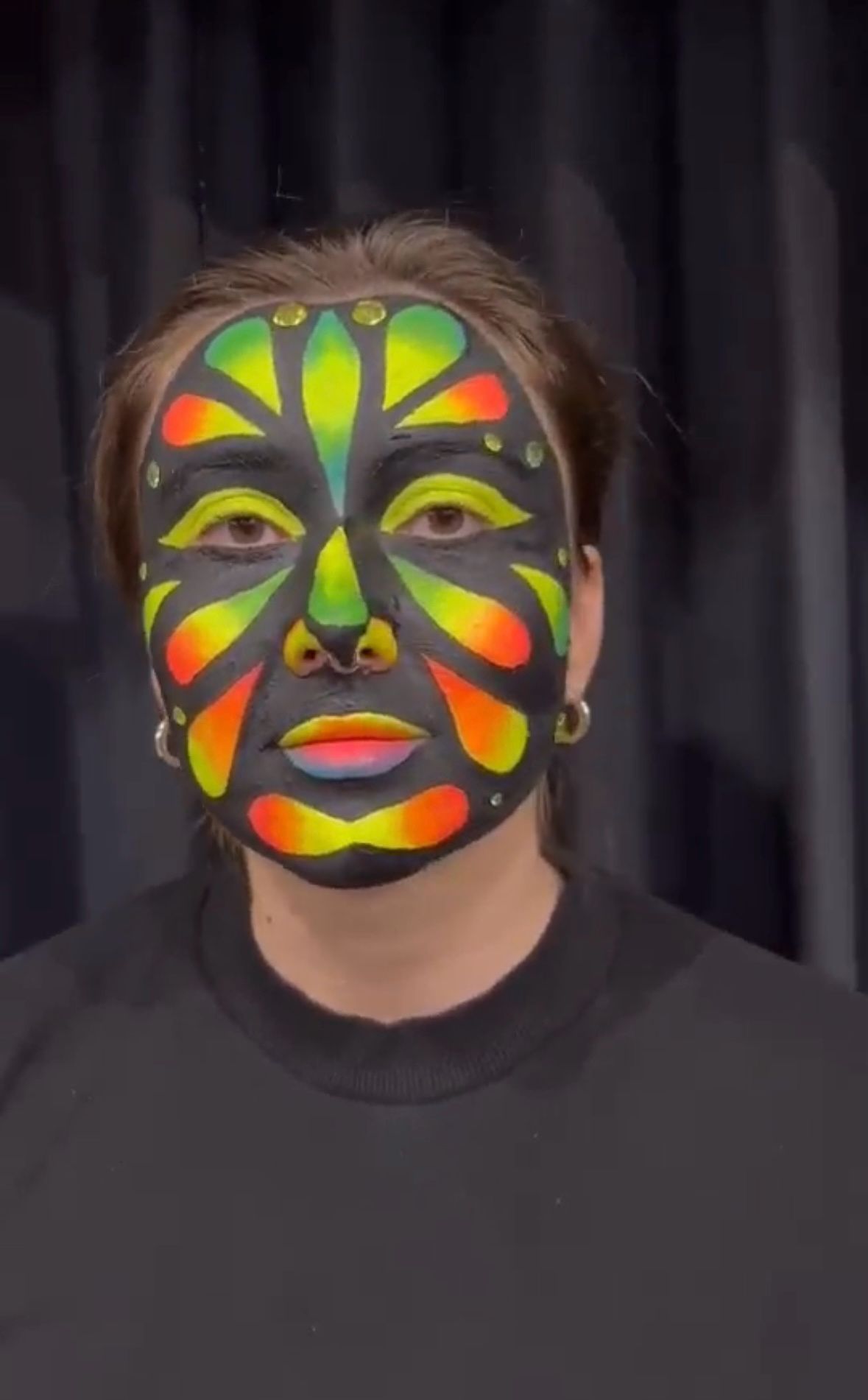 Student with her face painted in the neon yellow, orange and black like a butterfly