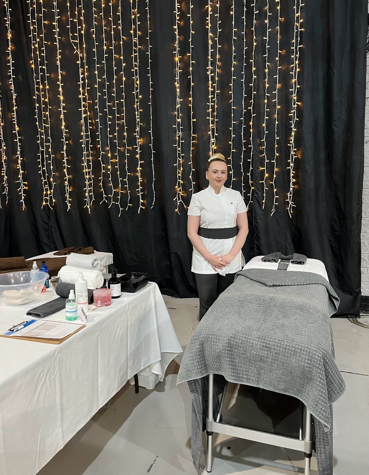 Student standing next to massage bed