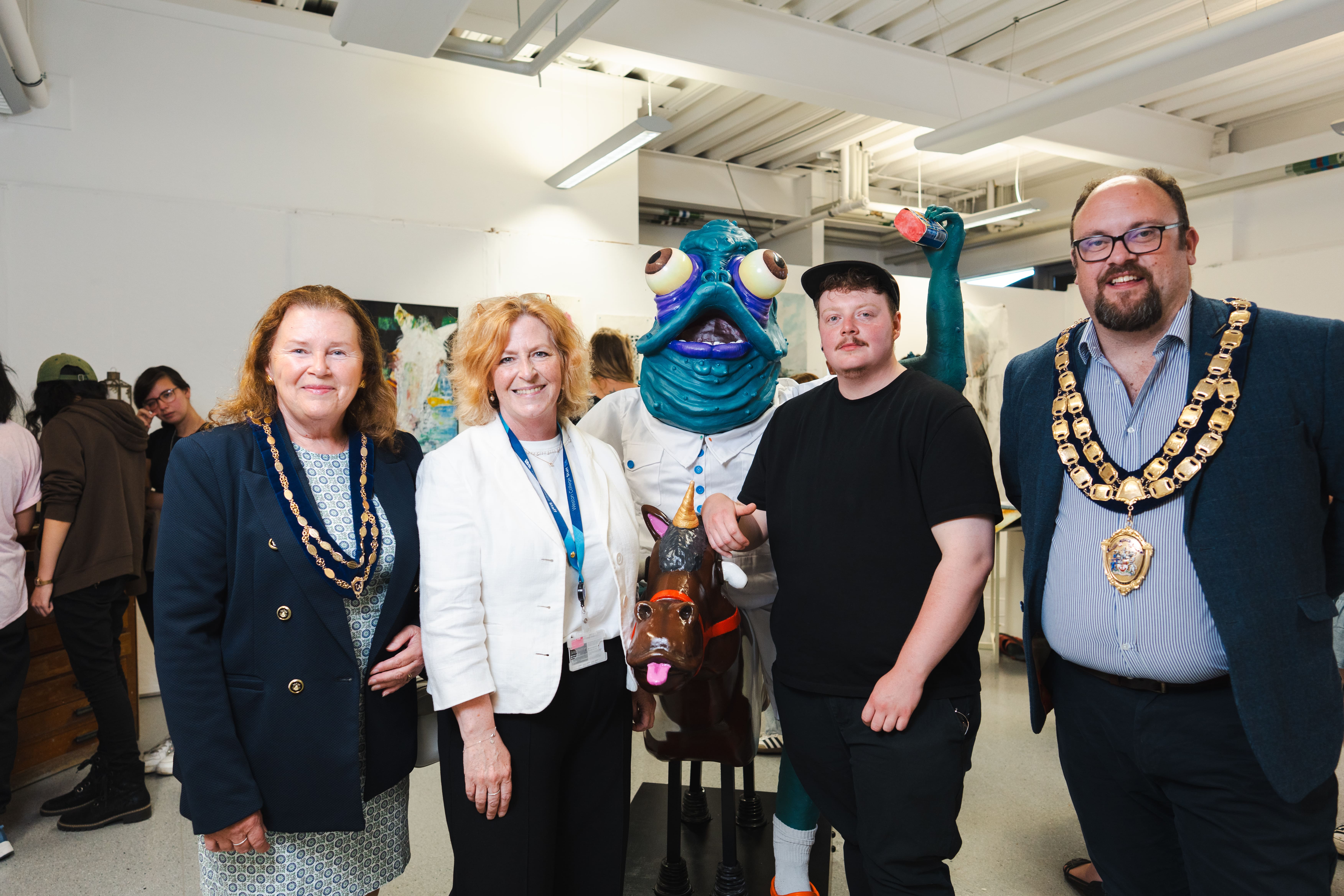 2 Weston super mare councillors, the Weston college principal, stand with learner and his art project