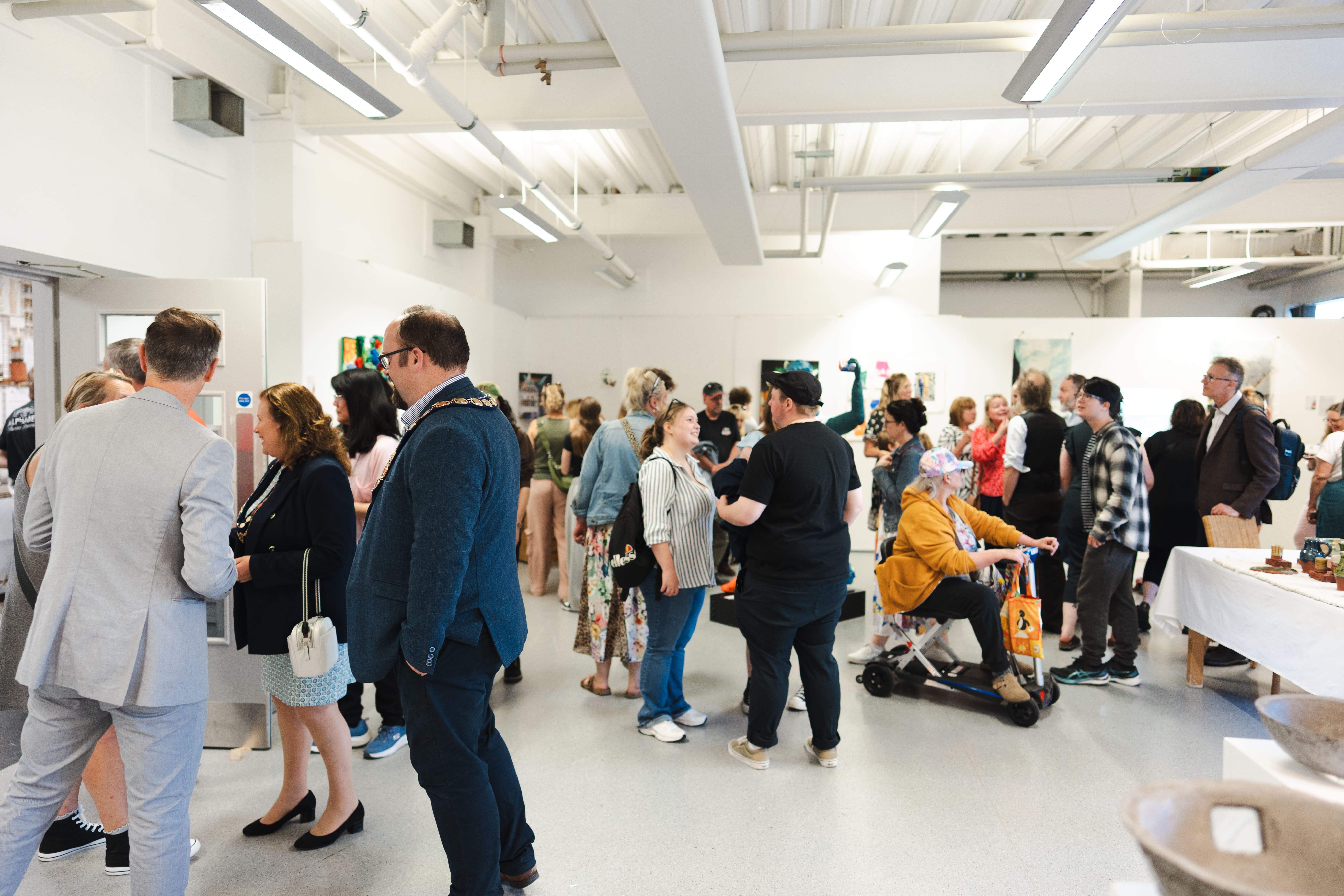 a gathering of people in a art exhibition hall