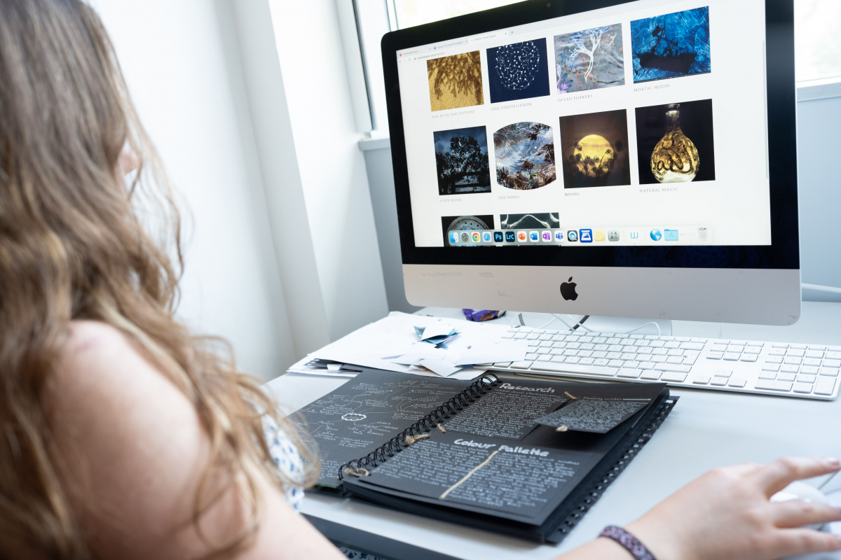 close up of a student doing art research on an apple mac 