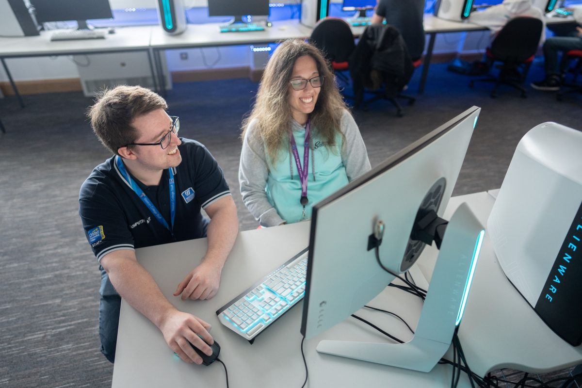 lecturer helps student at their computer