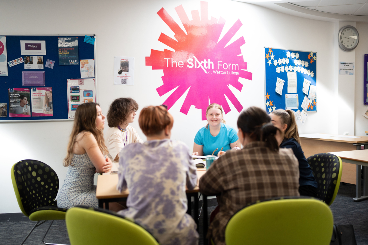 Students sitting round a table in sixth form communal room