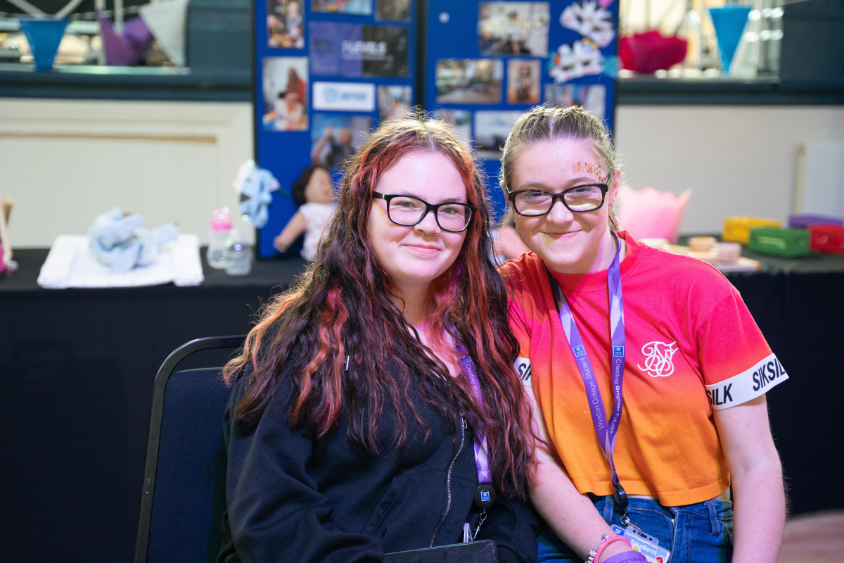 2 female college students smiling at the camera