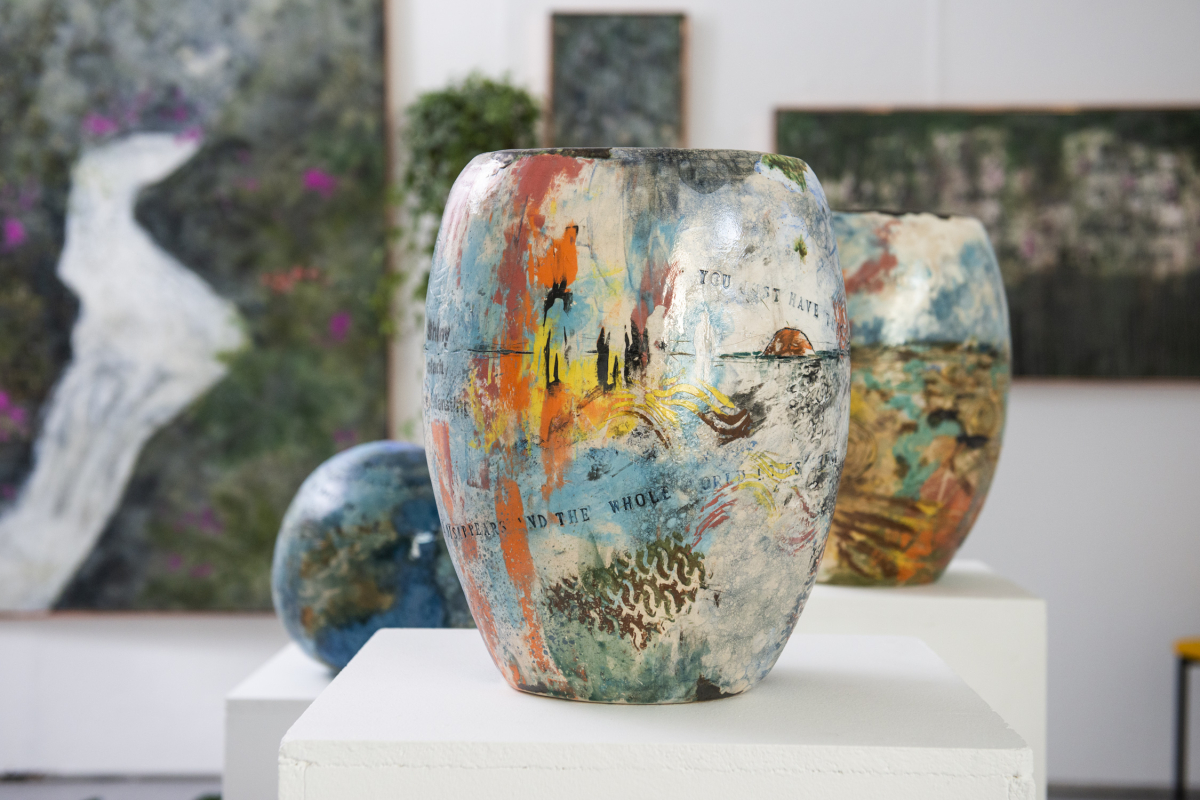 a couple of artistic vases sitting on top of a white pedestal