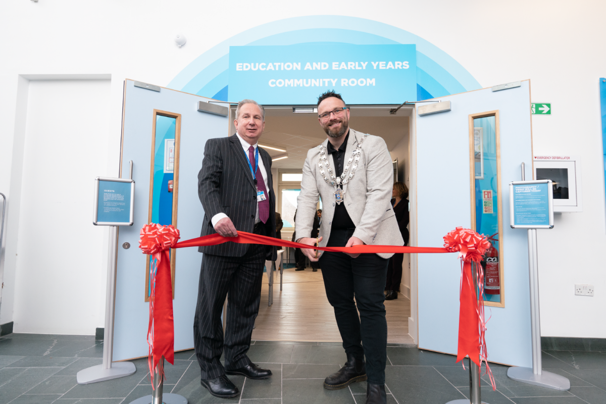 Sir Paul Phillips and the Weston-Super-Mare mayor standing in front of a red ribbon about to cut it to open new early years community room