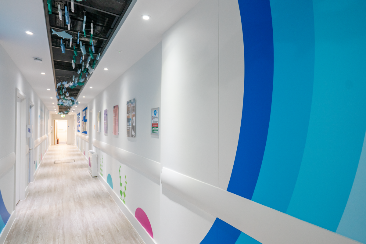a hallway with a white wall with blue and white circles and signs