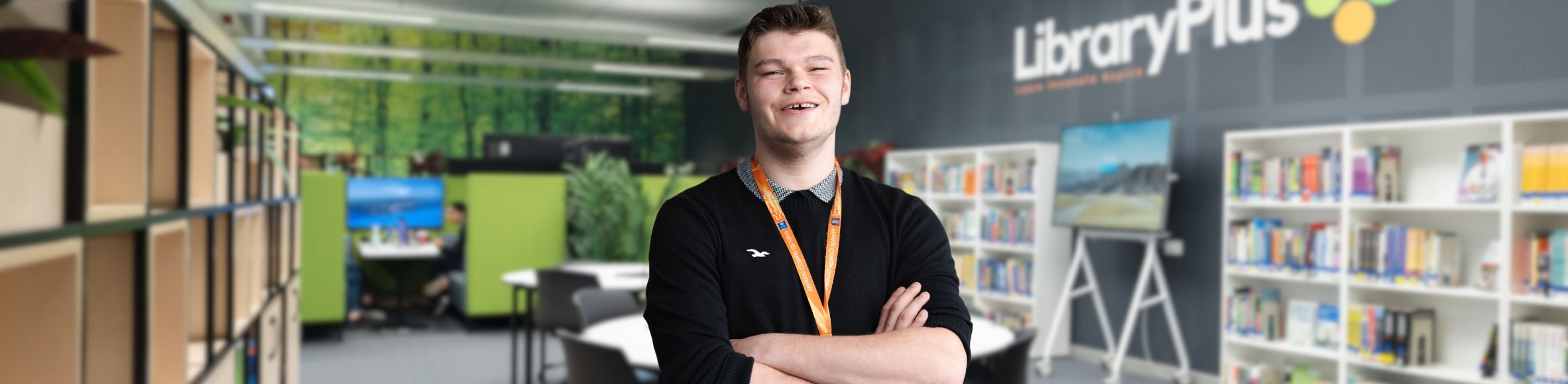 Student stood smiling in library