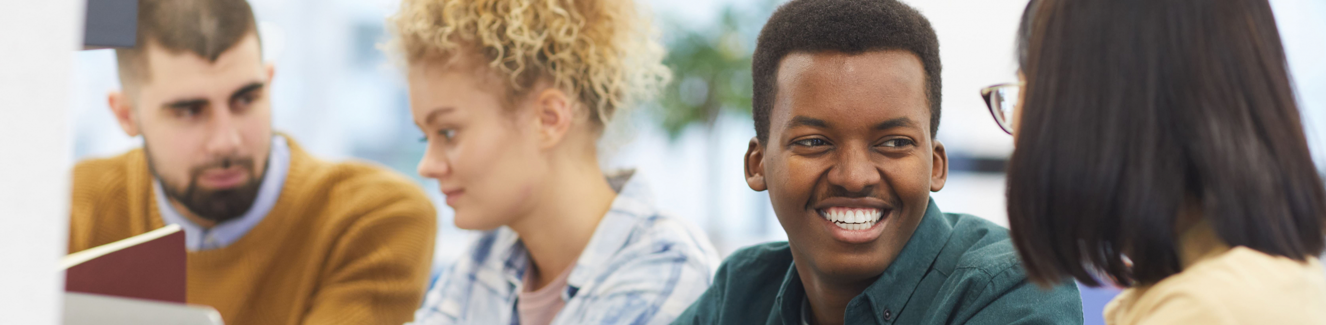 cheerful young people studying in library
