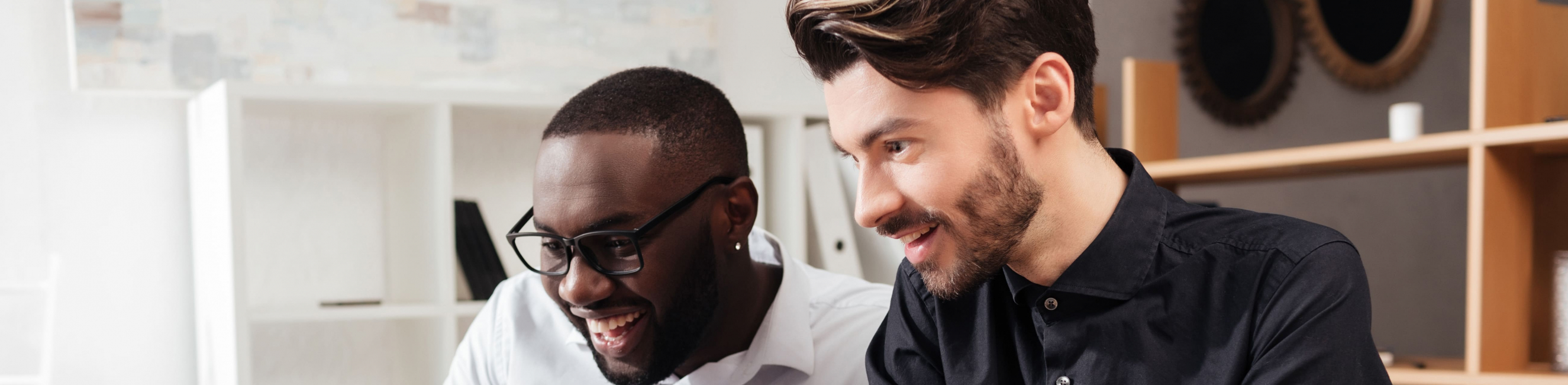 two men smiling at a computer