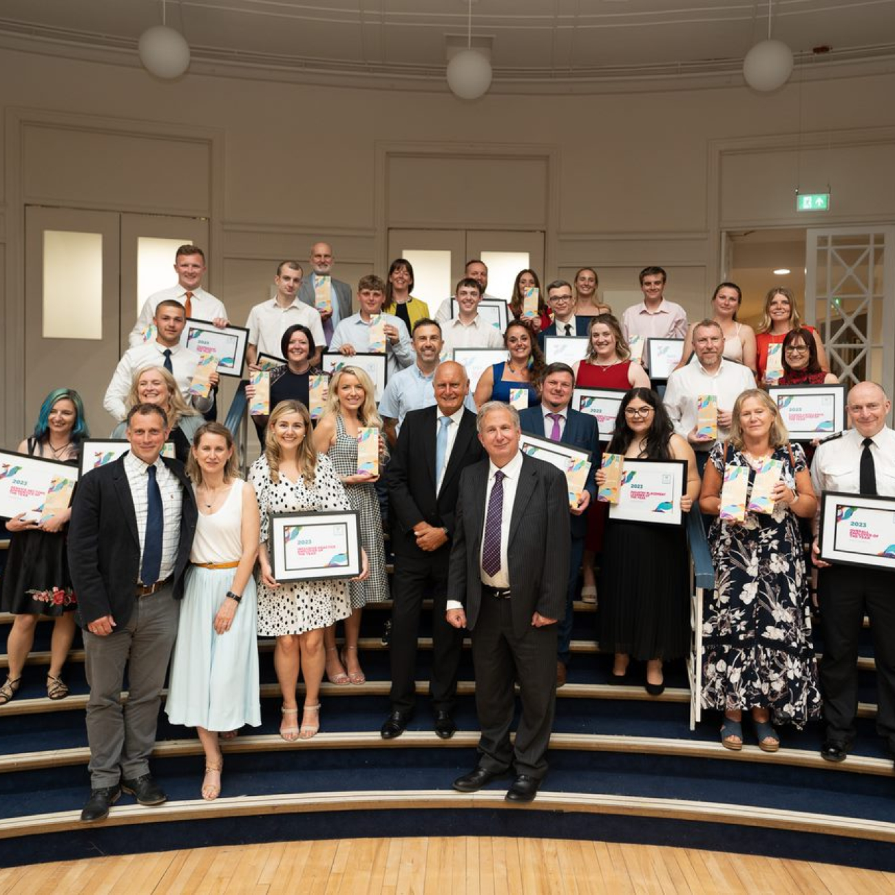 The winners of Weston College Business Awards gathered together on steps showcasing awards
