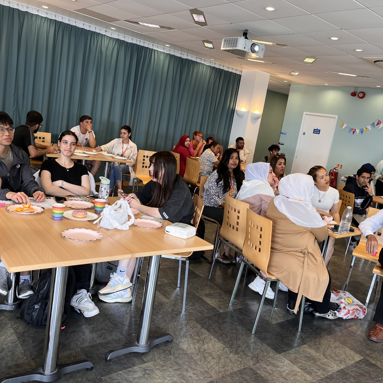 Learners sat together at ESOL celebration, whilst taking part in a quiz