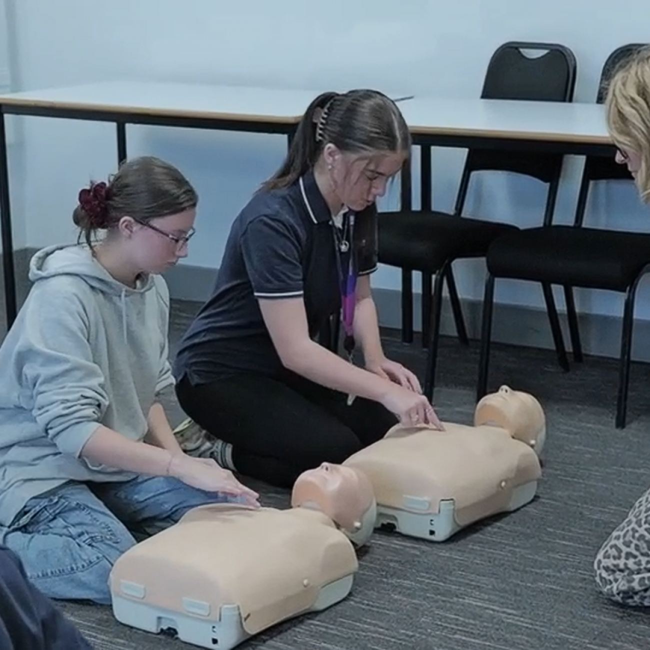 2 Students practicing CPR on a dummy