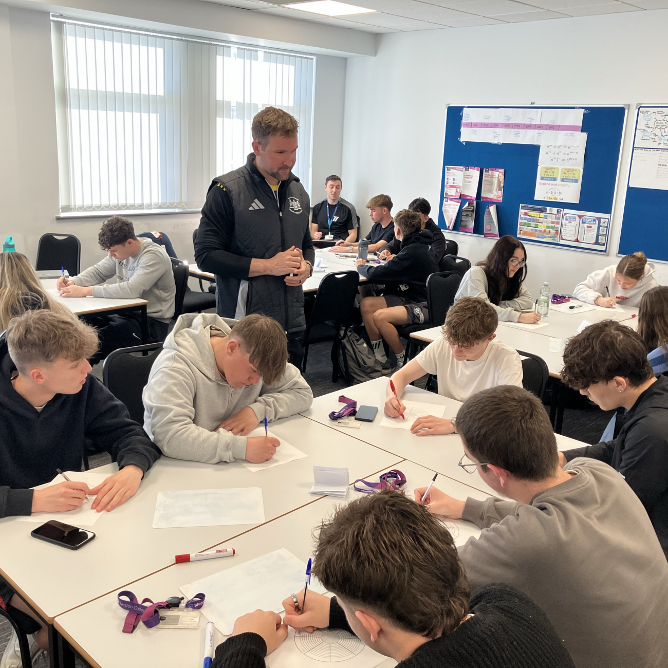 Sport students sat working on task sheets given by Marcus
