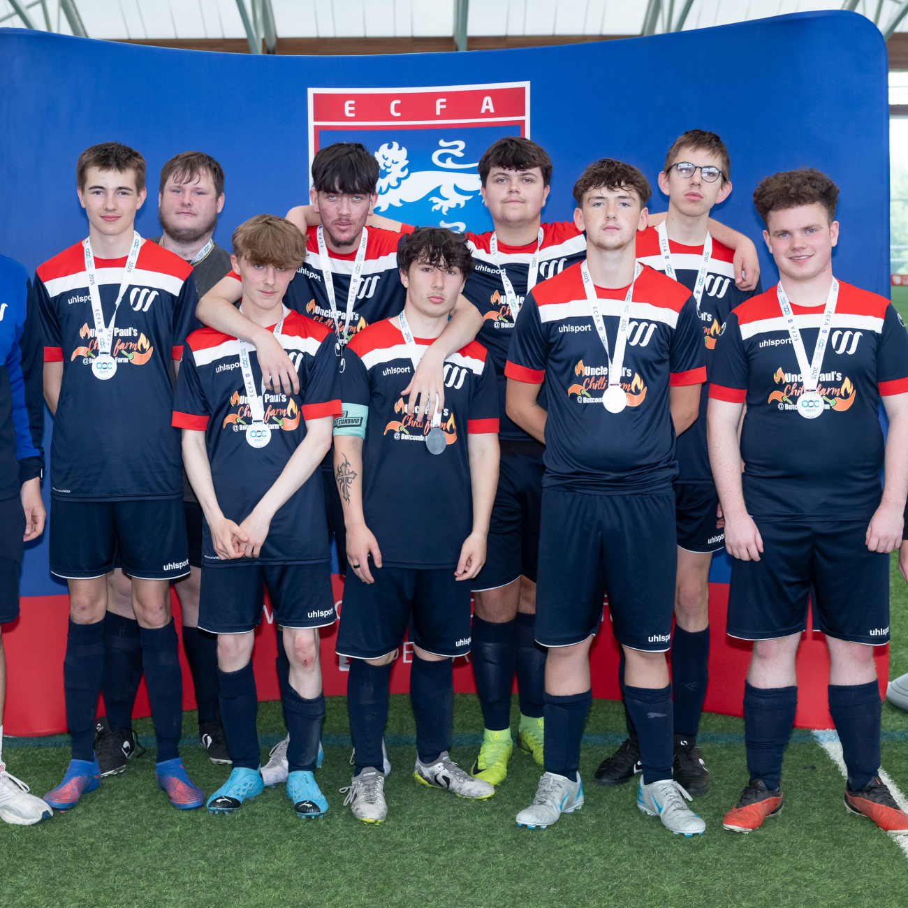weston college's football academy team standing in front of backdrop