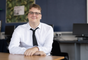 Toby sat at desk smiling