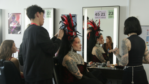 Student completing Moulin Rouge makeup on a model