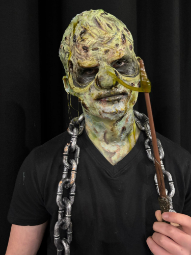 Student made up in prosthetics as a green monster