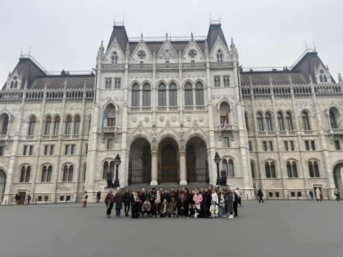 Early Years learners stood in front of a architectural building