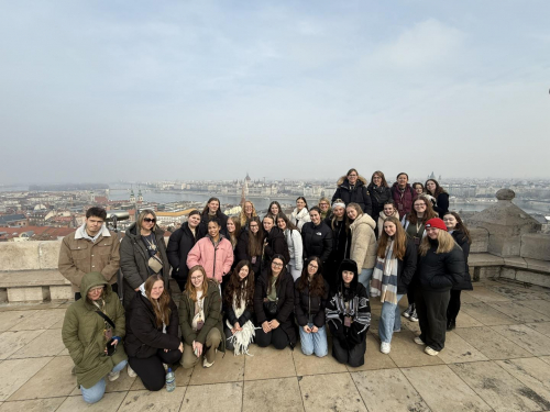 Early Years student standing on a high point with a full view of Budapest behind them